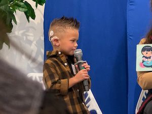 Child with cochlear implant using microphone