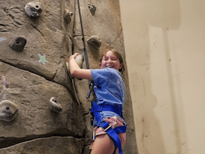 Lily climbing a rock wall